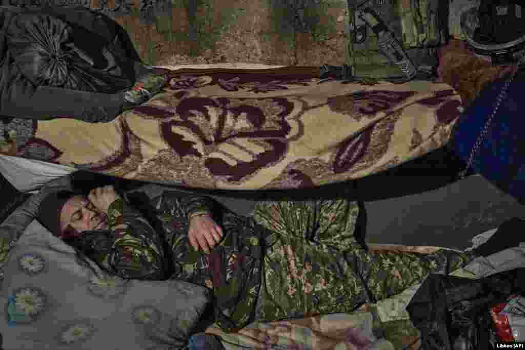 A Ukrainian soldier rests in a shelter along the front line.