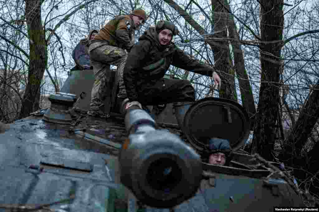 Украинские солдаты садятся на самоходную гаубицу 2С1 "Гвоздика" перед ее выходом на огневую позицию