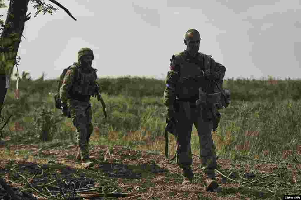 Українські військові повертаються з бою на свої позиції 