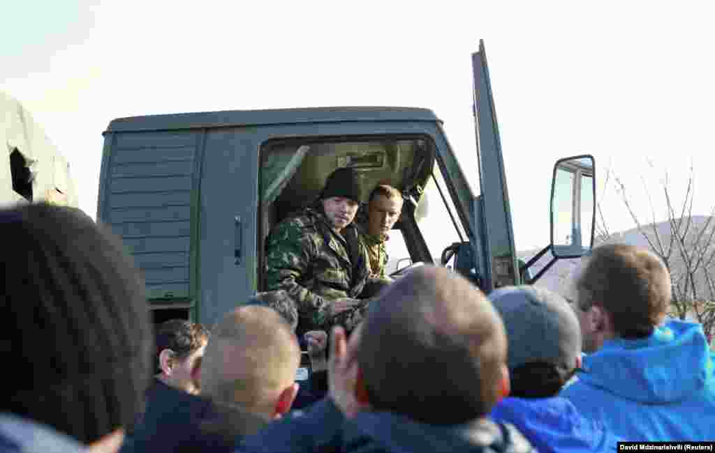 Місцеві жителі оточують вантажівку, якою керують українські військові, 3 березня 2014 року. Велика кількість проросійськи налаштованих місцевих жителів у Криму почали виходити на вулиці разом із російськими солдатами, посилюючи тиск на українські війська, які все більше опинялися в ізоляції на своїх військових базах. На той час у Криму, на думку експертів, приблизно 60 відсотків населення були етнічними росіянами