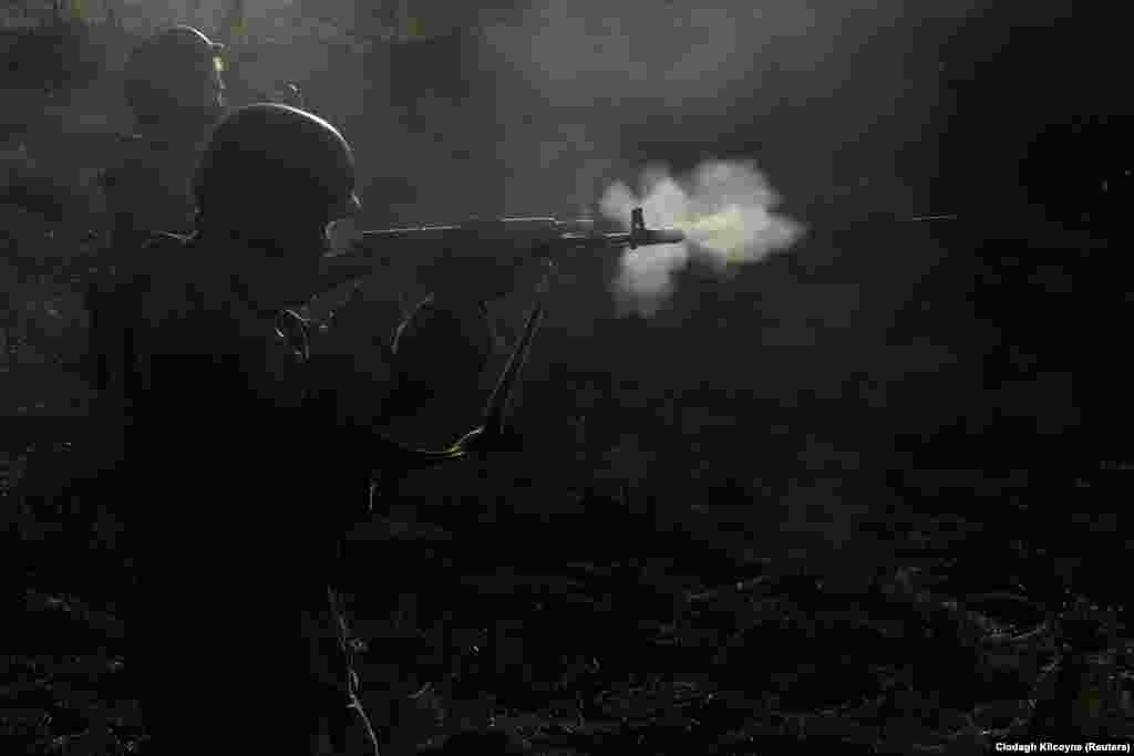 Военнослужащий-доброволец интернационального батальона «Карпатская Сечь» стреляет из автомата во время маневров у линии фронта в Кременной, Украина.