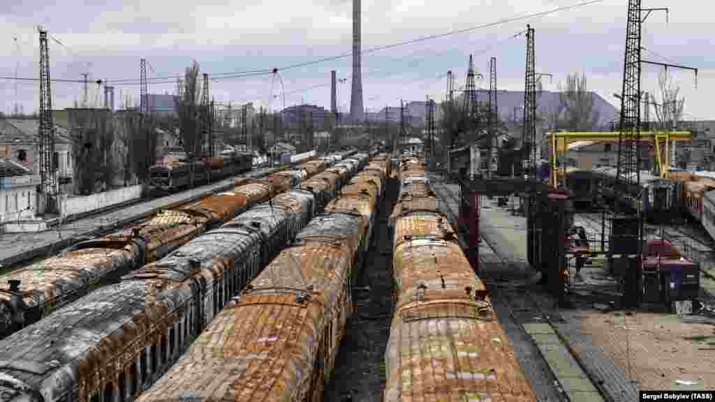 Burned-out trains on the same coastal track photographed in 2022. The slagheap in the background is on the site of the Azovstal factory. 