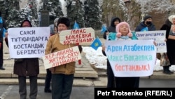 Люди с плакатами, с призывами освободить политических заключенных и не допустить передачи земли в аренду иностранцам, на митинге в Алматы. 14 ноября 2020 года.