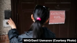 Женщина звонит в дверь с надписью «корь» в Республиканской инфекционной клинической больнице, город Бишкек, Кыргызстан. 2024 год. Фото: ВОЗ/Даниль Усманов