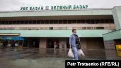 Қозоғистонлик аёл Олмаотадаги "Яшил бозор"дан егулик харид қилиб чиқмоқда, 2020 йил 18 марти.