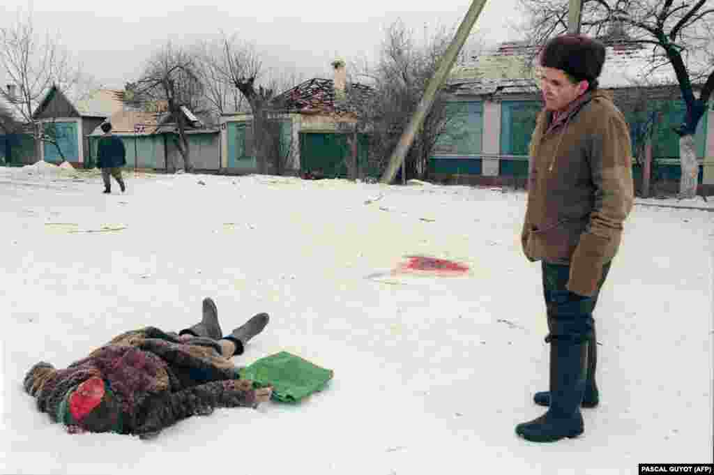 Ракетный обстрел настиг эту женщину на улице Грозного. Волонтеры из местных жителей и окрестных сел после бомбежек прочесывают улицы города. Если успевают, то вывозят тело до следующей бомбежки или захоранивают неподалеку. 24 января 1995 года.