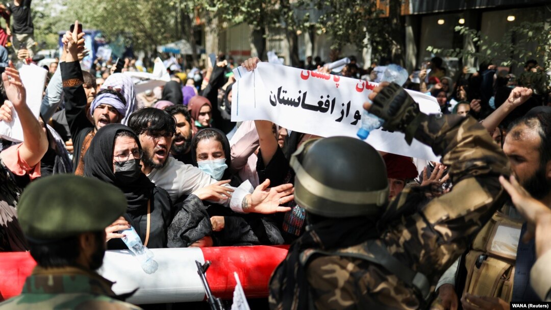 Soldați talibani în fața demonstranților ce poartă pancarte anti-Pakistan, ieri, 7 septembrie 2021, la Kabul. Pakistanul este acuzat de mulți afgani că este aliatul talibanilor. Deși numai indirect contra talibanilor, manifestația s-a încheiat cu focuri de armă. 