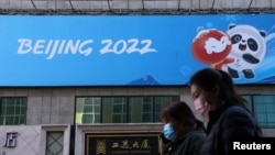 Кытай. Бээжин-2022 Кышкы Олимпиада оюндарынын белгиси түшүрүлгөн баннер. 