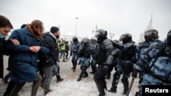 Демонстранти и полициски службеници на анти-владиниот протест во Москва.