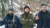 Доку Умаров позирует с двумя неизвестными боевиками