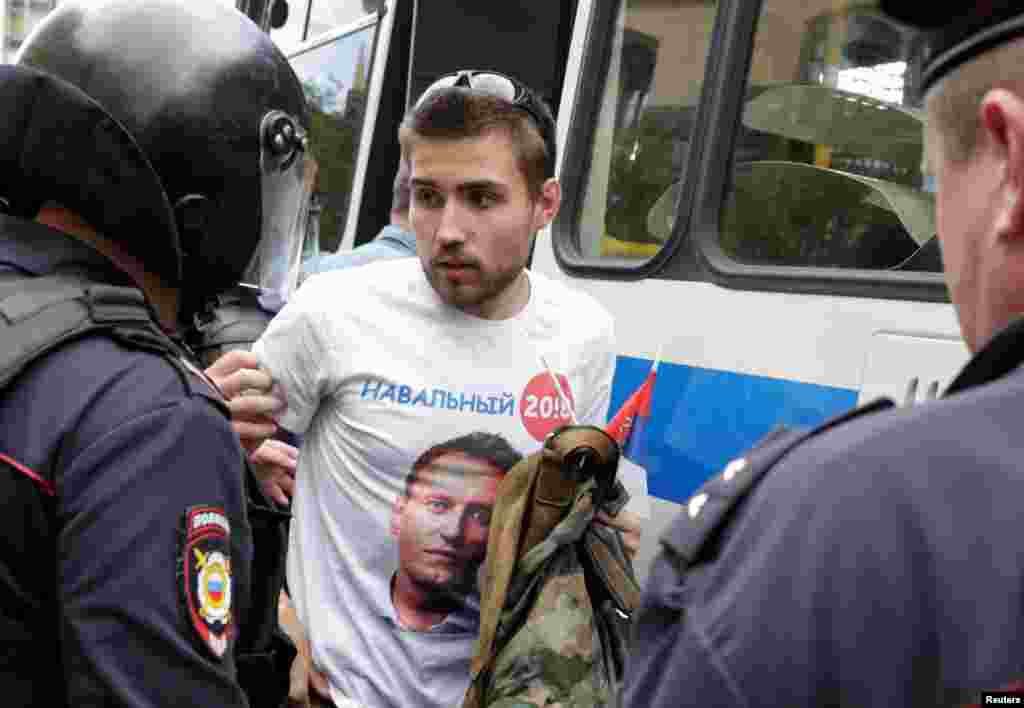Полиция задерживает человека в майке с символикой президентской кампании Алексея Навального, Москва.