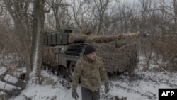 Український танкіст 68-ї бригади йде поруч з танком Leopard 1A5 на позиції поблизу Покровська, схід Донецької області, 13 грудня 2024 року