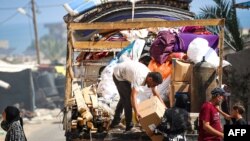 Palestinieni strămutați părăsesc o zonă nesigură din Rafah în timp ce forțele israeliene continuă să bombardeze militanții Hamas din orașul situat din sudul Fâșiei Gaza.