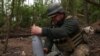 Un militar ucrainean pregătește un obuz pentru ca un obuzier să tragă în pozițiile rusești de pe linia frontului, lângă orașul Soledar, pe 6 mai.