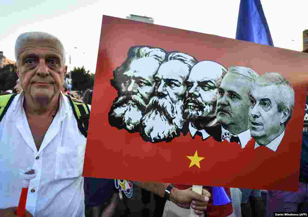 Протестувальник тримає плакат, на якому лідери лівої соціально-демократичної партії Румунії зображені разом з лідерами комунізму