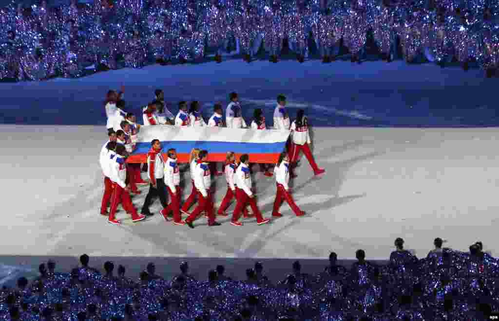 Орусиянын желегин стадионго көтөрүп баратышат.