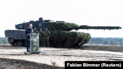 Канцлер Німеччини Олаф Шольц виступає на тлі танку Leopard 2 на військовій базі Берген, жовтень 2022 року