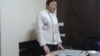 Умит Нуртазина за столом у дверей своей квартиры. Астана, 24 декабря 2013 года.