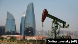 Нафтавая помпа-журавель на тле хмарачосаў Баку