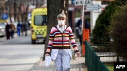 North Macedonia - A medical staff wears a protective mask as she walks outside the University Clinic in Skopje on March 11, 2020.