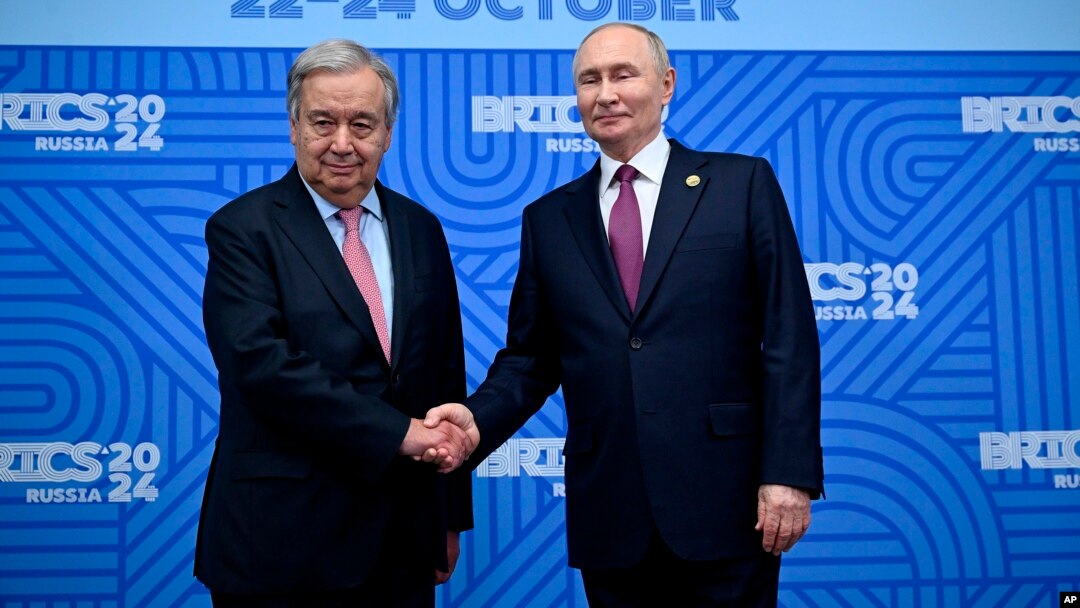 Secretarul general al ONU, Antonio Guterres, dă mâna cu președintele rus Vladimir Putin la summitul de la Kazan, 24 octombrie. 